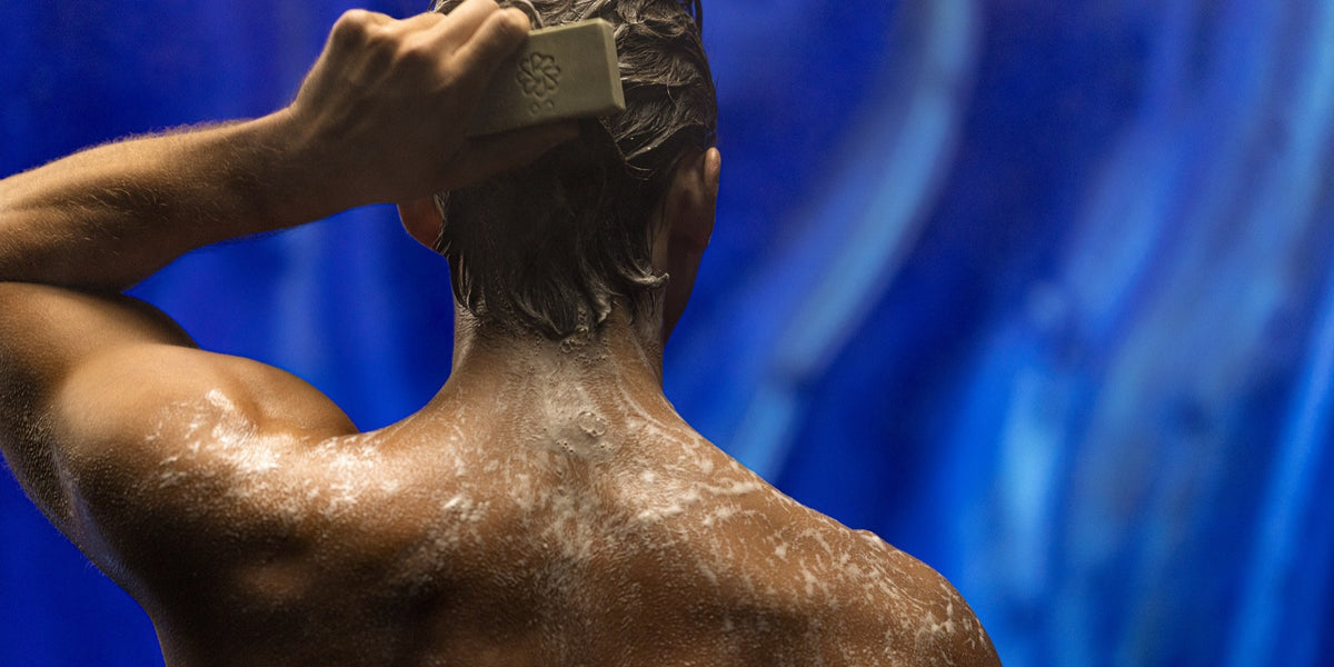 Man washing hair with a JIVANTRA One & Done bar in the shower